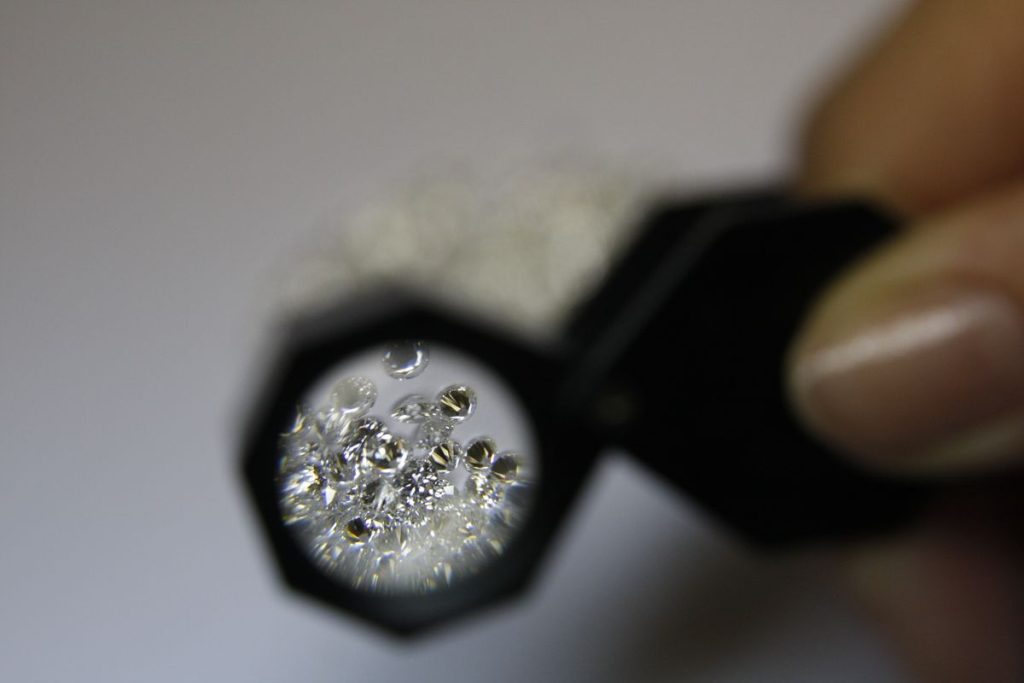 Jeweller's loupe over loose diamonds